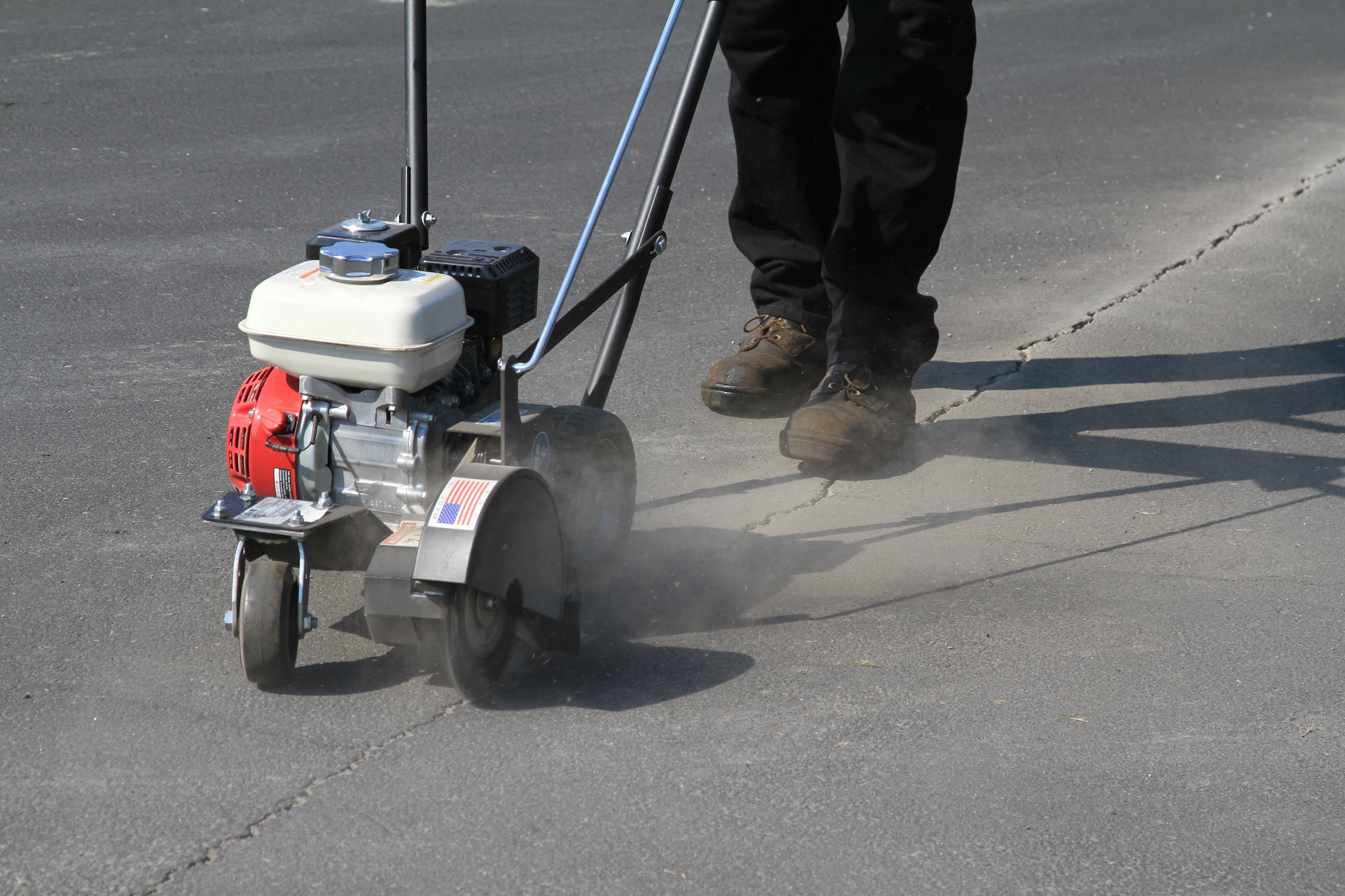 Cleaning and preparing the parking lot with a crack cleaner before applying sealcoat and traffic marking paint. Learn how to stripe a parking lot.