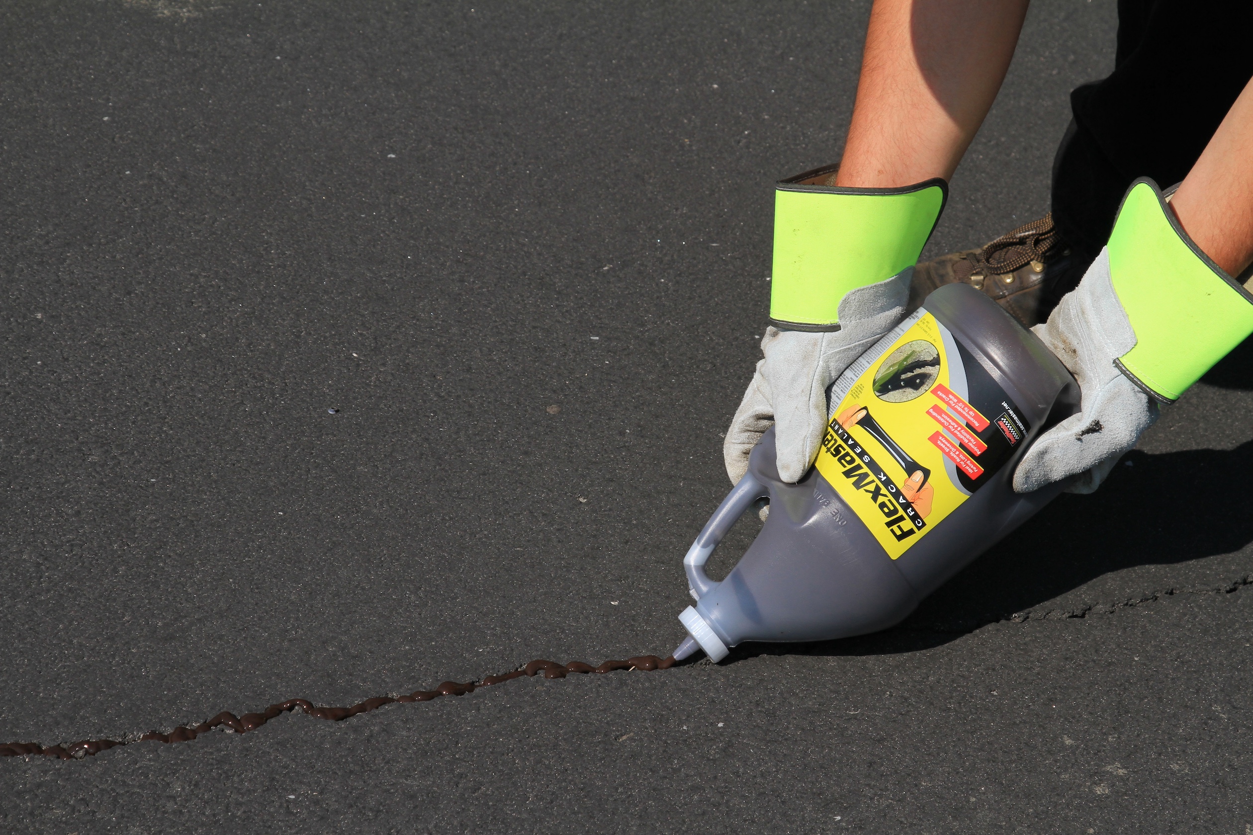 FlexMaster | Cold-Pour Crack Filler | SealMaster FlexMaster cold-pour crack filler being applied on a parking lot.