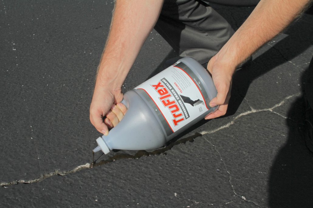 Cold-pour crack filler TruFlex being applied to a crack on a parking lot