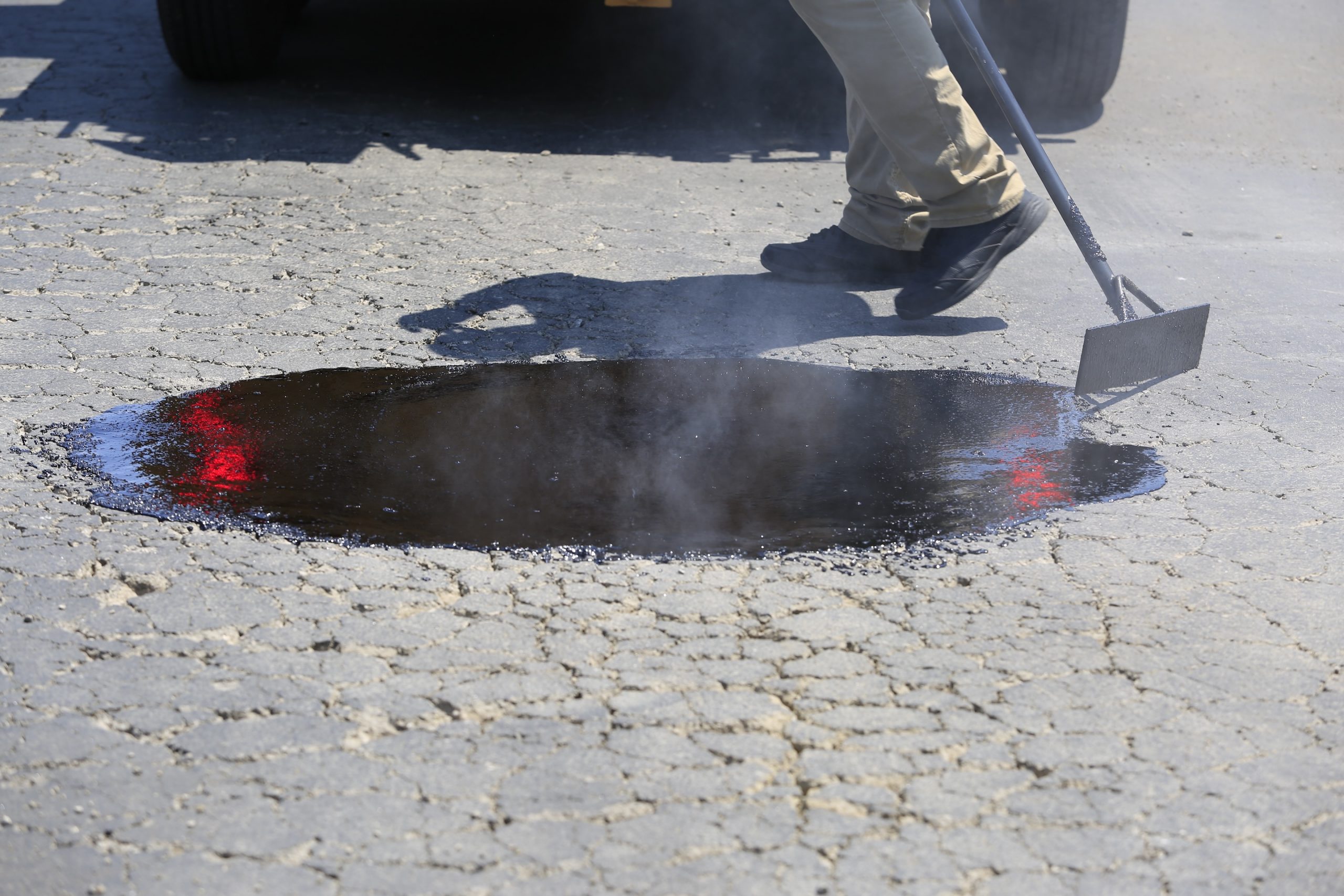SealMaster mastic application on distressed pavement. SealMaster mastic application on distressed pavement.