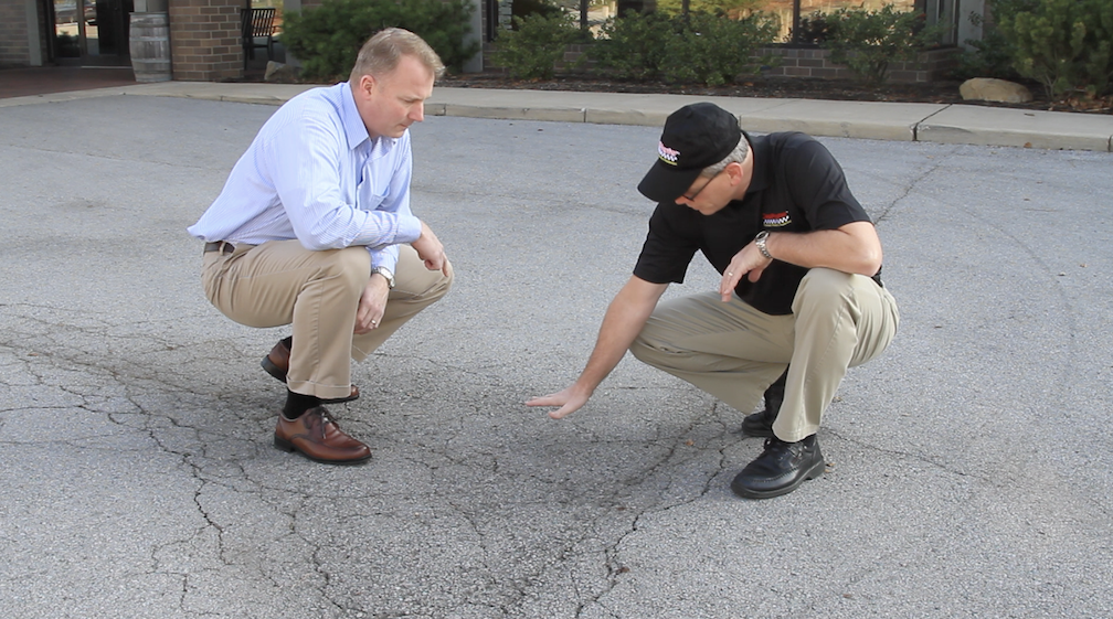SealMaster representative discussing pavement maintenance with a property owner.
