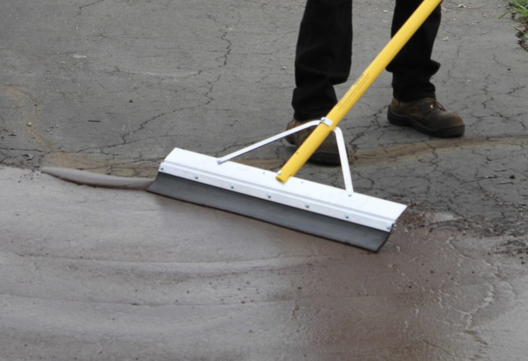 Application of SealMaster GatorPave trowelable patching material on a parking lot.