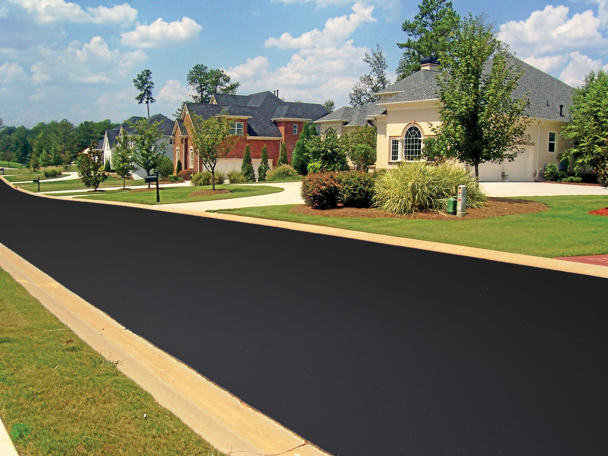 Fresh asphalt sealcoating on a residential street. SealMaster